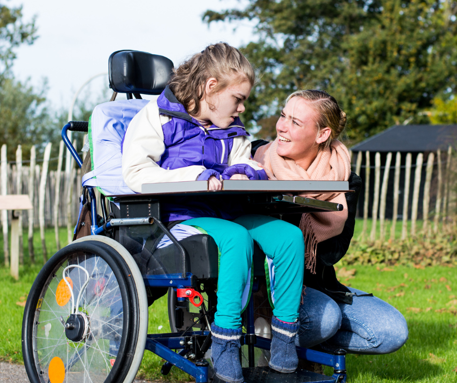 child in wheelchair with women